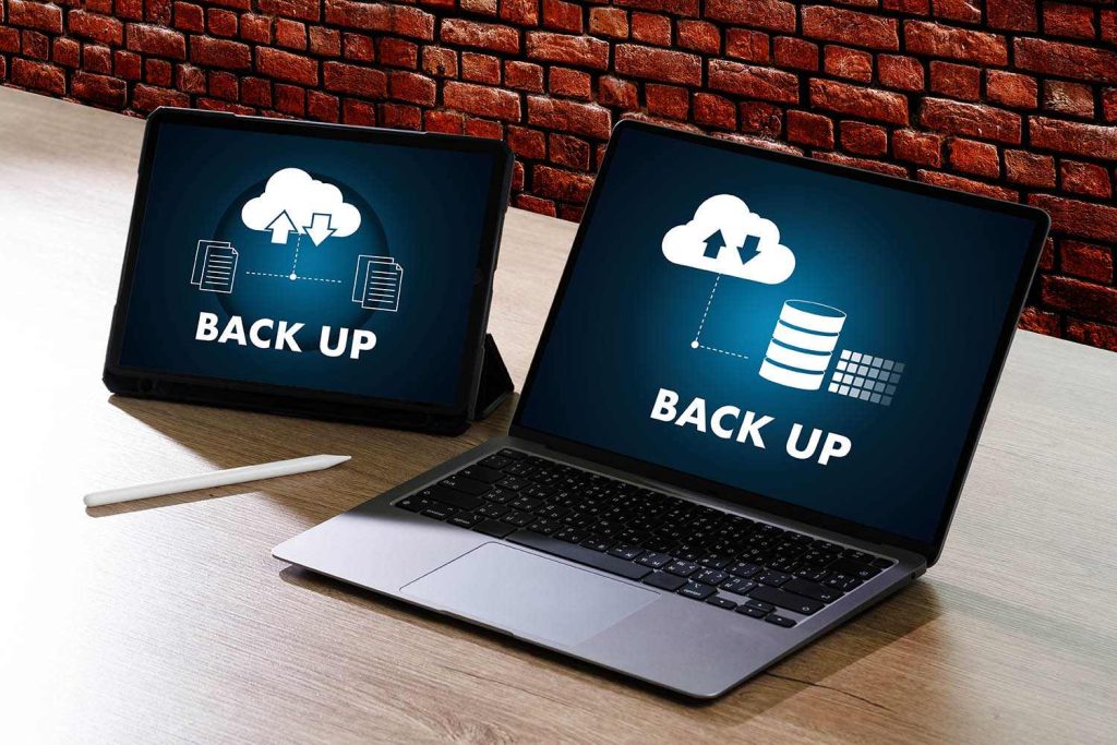 Twee laptops die het proces van WordPress Backup weergeven, regelen dit